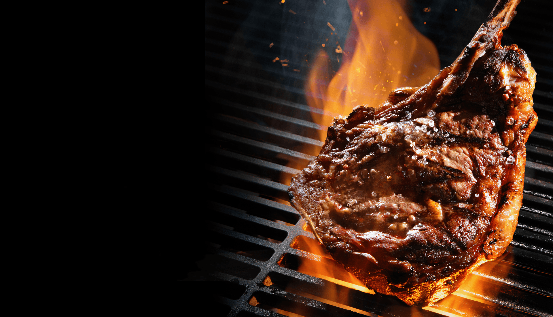 Tomahawk steak over open flames on the charcoal grill
