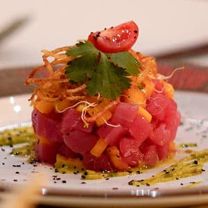 Tartare tower crowned with cherry tomato and cilantro